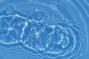 Bluewater bubbles on the surface ripples. Defocus blurred transparent white-black colored clear calm water surface texture with splash and bubbles. Water waves with shining pattern texture background. photo