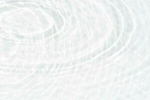 White water with ripples on the surface. Defocus blurred transparent white colored clear calm water surface texture with splashes and bubbles. Water waves with shining pattern texture background. photo