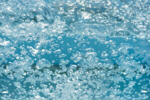 Bluewater bubbles on the surface ripples. Defocus blurred transparent white-black colored clear calm water surface texture with splash and bubbles. Water waves with shining pattern texture background. photo