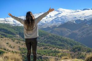 Latina woman on her back with arms outstretched happily enjoying the scenery outdoors in winter. photo