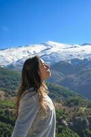 latina mujer, larga cabello, respiración Fresco aire a el parte superior de el montaña,sierra Nevada España foto