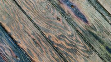 Background of wooden surface made of boards with multicolored spots from humidity, diagonal lines, top view, closeup. photo