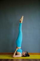 woman doing yoga pose head stand photo