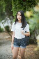 asian teenager wearing short jeans standing outdoor photo