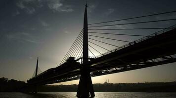 silhueta do a metro ponte às a dourado buzina, Istambul dentro pôr do sol video