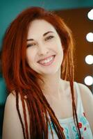 Smiling red-haired girl with long dreadlocks. photo