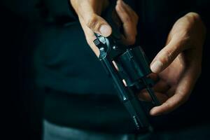 Men's hands check for bullets in revolver barrel. photo