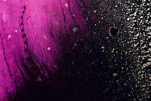 Fluid Art. Golden spray particles and purple waves on black background. Marble effect background or texture photo