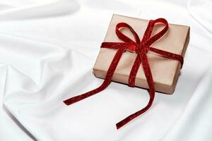 Zero waste Gift box with red velvet ribbon on white silk sheet. Romantic Valentines day concept photo