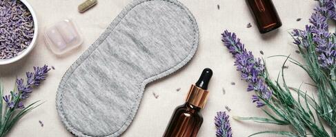 Healthy night sleep concept. Sleep mask and lavender products for healthy sleep on textile banner photo