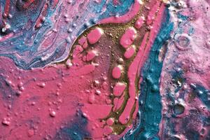 Fluid Art. Metallic gold abstraction on pink waves. Marble effect background or texture photo