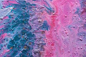 Fluid Art. Embossed pink and turquoise craters and drips of paint. Marble effect background or texture photo