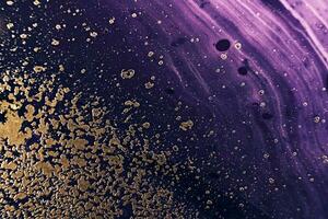 Fluid Art. Metallic gold particles and black purple waves. Marble effect background or texture photo