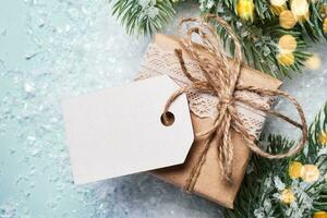 regalo caja lleno en papel, decorado con cordón y enroscarse. eco Navidad decoración con blanco etiqueta Bosquejo foto