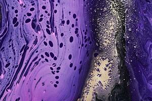 Metallic gold abstraction on purple waves. Fluid Art. Marble effect background or texture photo
