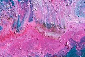 Fluid Art. Embossed strokes and drips of pink paint. Marble effect background or texture photo