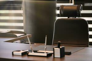 Business office workplace. Sunlight at work place for chief, boss or other employees. Table and comfortable chair. Light through the half open blinds photo