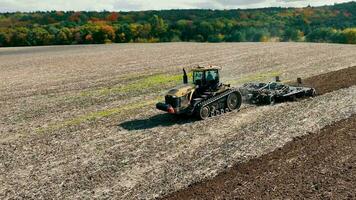 aérien Haut vue de une tracteur avec une charrue labour le atterrir. préparation de le agricole champ pour semis. labour vue de au dessus video