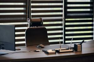 Business office workplace. Work place for chief, boss or other employees. Table and comfortable chair. Light through the half open blinds photo