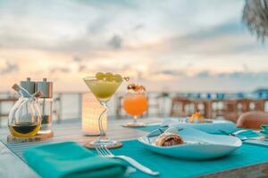 Comida de desayuno de lujo jugo fresco en mesa de madera, con hermoso resort tropical y fondo con vista al mar, vacaciones de verano por la mañana y concepto de vacaciones románticas, viajes de lujo y estilo de vida foto