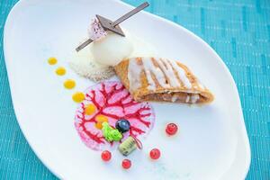 Gourmet dessert ice cream and cake with fruits on elegant close-up view. Plate with different sweet desserts and cocktails on colorful table photo