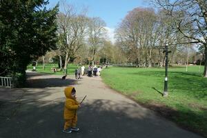 Cute Asian Pakistani Baby Ahmed Mustafain Haider is Enjoying The Beautiful Sunny Day at Wardown Public Park of Luton Town of England UK. Image Was Captured on 03-April-2023 photo