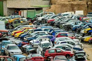 un grande lote de carros son apilado arriba en un estacionamiento lote foto