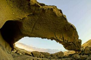 a large rock formation in the middle of a desert photo