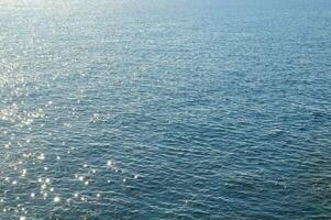 the sun shines on the water in the ocean photo