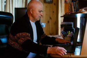 Portrait of a senior man in front of a laptop computer photo