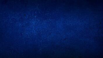 blank blue texture surface background with dark corners. blue grainy cement wall background with space for text. photo