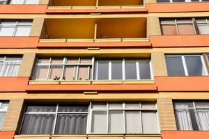 un naranja edificio con muchos ventanas y balcones foto