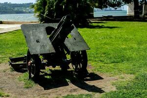 a cannon on the grass in front of a body of water photo