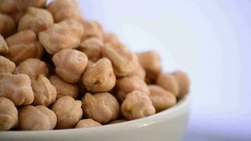 Chickpeas vegetables gyrating on a bowl on white background video