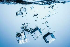 ice cubes falling down. ice cubes on blue background. splash on blue. ice cubes in water photo