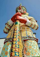 a colorful statue of a man holding a stick photo