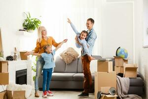 Happy family moving home with boxes around photo