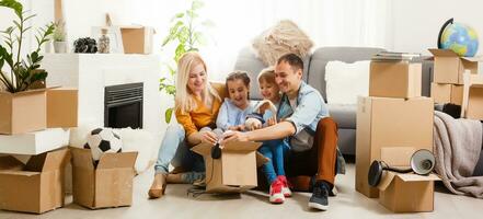 Happy family with cardboard boxes in new house at moving day. photo