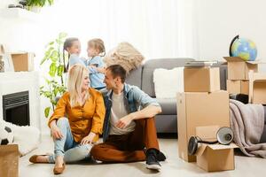 Happy family with cardboard boxes in new house at moving day. photo