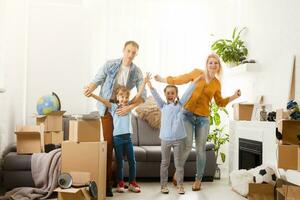 Happy family moving home with boxes around photo