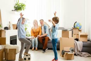 Happy family moving home with boxes around photo