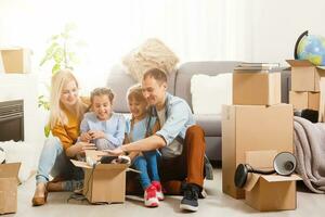 Happy family moving home with boxes around photo