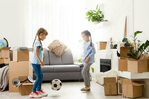 Little girls near cardboard box, moving to a new apartment photo