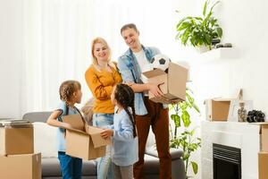 Family with cardboard boxes standing in row at home photo