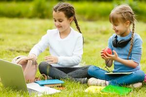 kids on the picnic in school grass yard are coming eat lunch in box. parent take care of childcare. photo