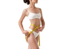 Female body with the drawing arrows on it isolated on white. Fat lose, liposuction and cellulite removal concept. photo