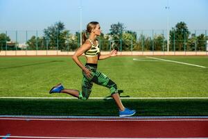 A female athlete runs along the treadmill. Sport background photo