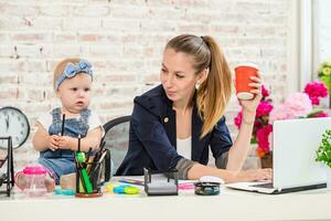 Businesswoman mother woman with a daughter working at the laptop photo