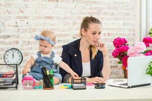 Businesswoman mother woman with a daughter working at the laptop photo