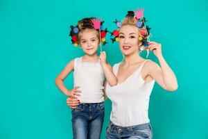 Funny family on a background of bright blue wall. Mother and her daughter girl with a paper accessories. photo